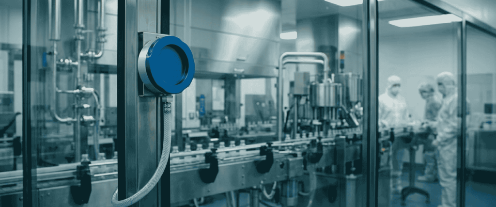 EU GMP Annex 1 compliant pharmaceutical cleanroom with sterile filling line, stainless steel equipment, and workers in protective suits
