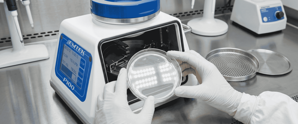 EU GMP Annex-compliant laboratory testing with gloved hands holding a petri dish near a microbial colony counte
