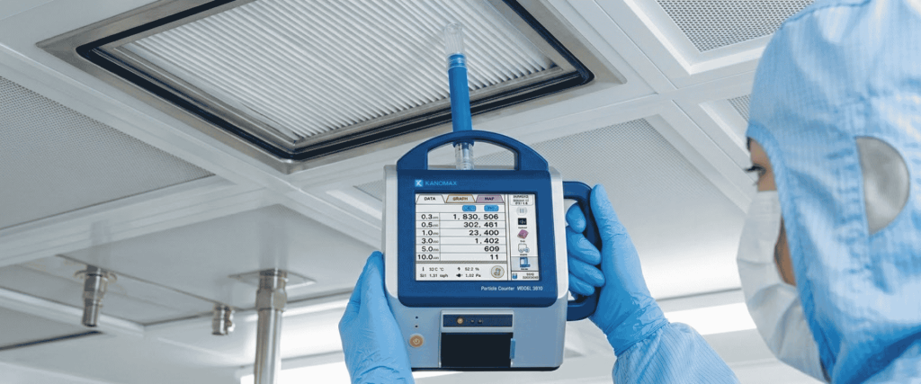 ISO 14644-1 cleanroom particle counter measuring airborne particles under HEPA-filtered ceiling