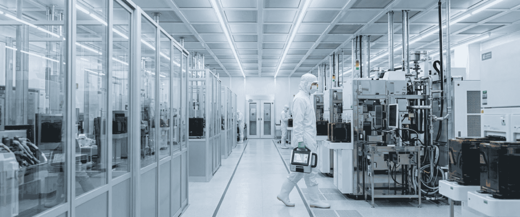 SO 14644-1 cleanroom with workers in protective suits operating advanced semiconductor manufacturing equipment