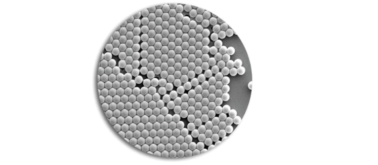 Surf-Cal microscopic view showing hundreds of uniform spherical particles arranged in a dense pattern