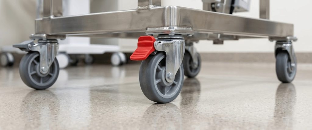 Caregiver injuries prevention with hospital bed wheels and safety brake in a medical facility