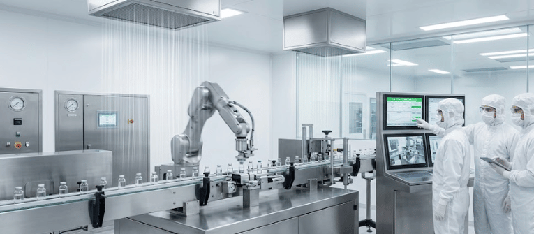 Clean pharmaceutical production line with robotic arm placing vials on conveyor, three technicians in sterile suits monitoring control screens