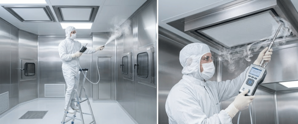 Technician in cleanroom suit disinfecting stainless-steel cleanroom surfaces and HVAC vents using fogging and handheld monitoring equipment