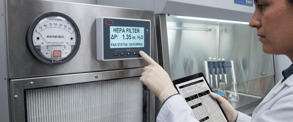 HEPA Filtration system check in lab with technician monitoring filter pressure and control panel for clean air performance