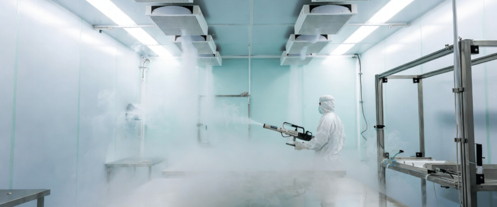 ISO Class 5 Cleanroom with technician sanitizing equipment in a sterile room using fogging spray and filtration systems