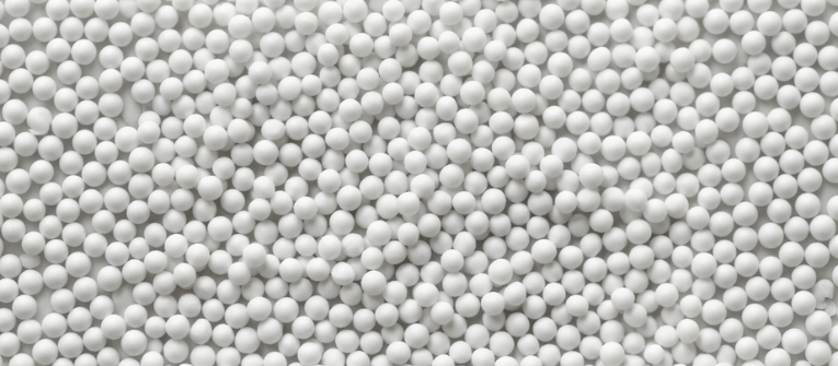 PSL Sphere Sizes white ceramic spheres arranged tightly in bulk, showing uniform ball sizes for industrial and decorative use