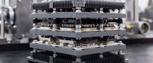 Industrial machine with stacked metal components and cooling fins in a factory setting, showing precision engineering detail