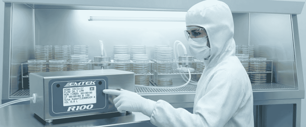R100 Controllers sterile lab controller with technician operating EMTEK R100 unit beside stacked Petri dishes