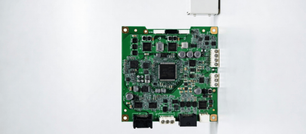 UV Electronic circuit board with connectors, microchips, and a small white component on a clean
